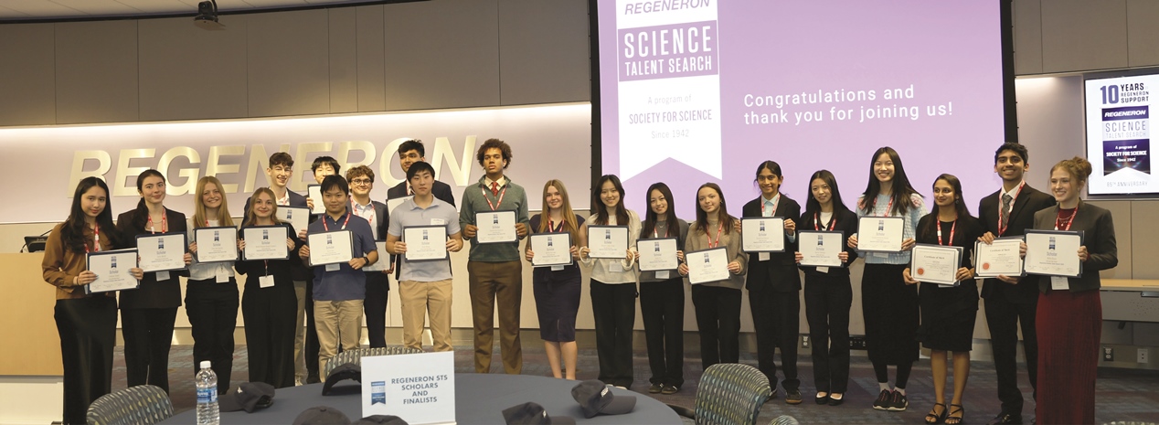 Group of students holding certificates on stage at a Regeneron Science Talent Search awards event.