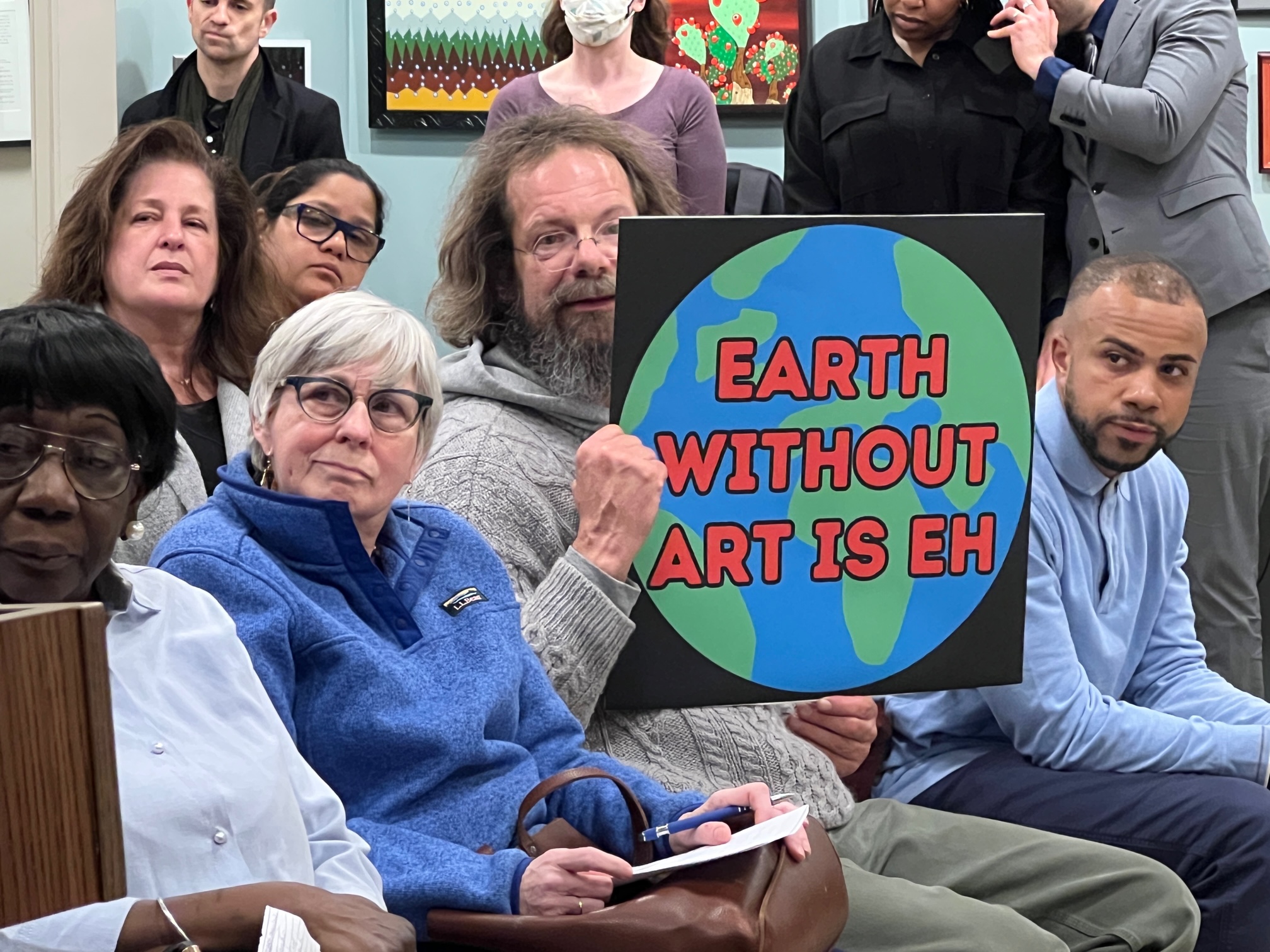 picture of man holding sign at public input session