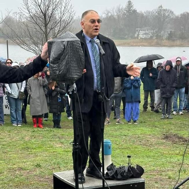 Judah speaking outdoors at the Hands Off rally in Mamaroneck
