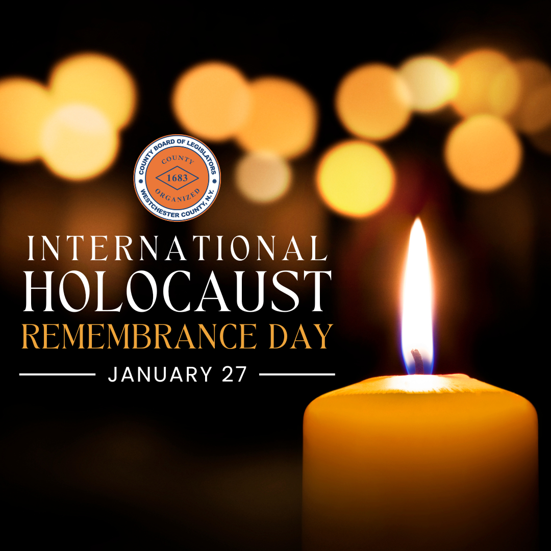 Westchester County Board of Legislators tribute for International Holocaust Remembrance Day on January 27, featuring a lit candle against a background of blurred glowing lights.